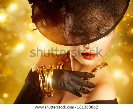 Glamour Woman Portrait over Holiday Gold Background.Luxury Golden Jewelry. Gorgeous Vogue Style Lady wearing Hat and Gloves. Jewellery. Vintage Styled Retro Girl