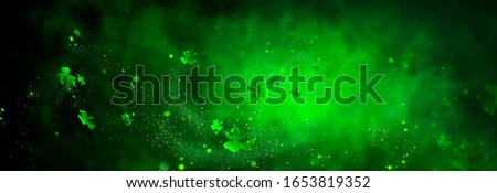 St. Patrick's Day abstract green background decorated with shamrock leaves. Patrick Day pub party celebrating. Abstract Border art design magic backdrop. Widescreen clovers on black with copy space. Stok fotoğraf © 