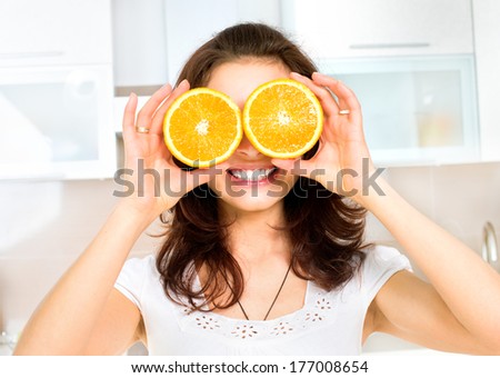 Portrait of Young and Healthy Funny Woman with Orange over Eyes in the Kitchen. Diet and Healthy Eating Concept, Vitamins