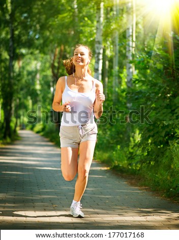 Running woman. Female Runner Jogging during Outdoor Workout in a Park. Beautiful fit Girl. Fitness model outdoors. Weight Loss. Healthy lifestyle. Morning