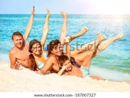 Happy Family Having Fun at the Beach. Joyful Big Family. Vacation and Travel concept. Summer Holidays. Parents with Children enjoying a holiday at the sea