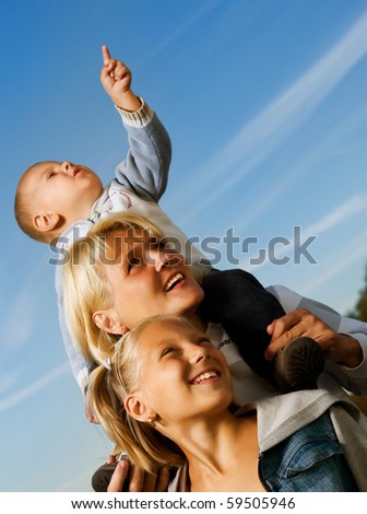 Healthy Family Outdoor.Happy Mother with Kids over blue sky