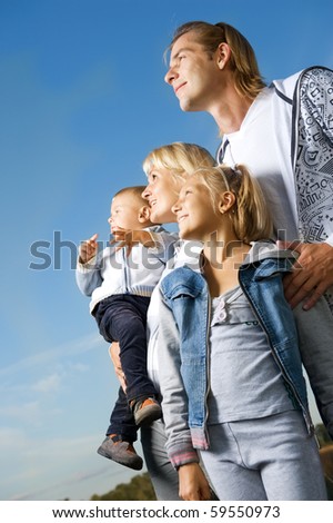 Healthy Family Outdoor.Happy Mother and Father with Kids over blue sky