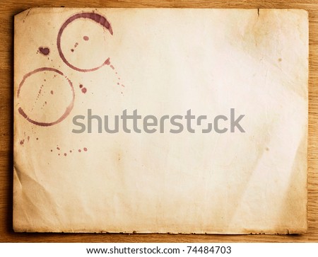 Old Paper sheet with stains over wooden background