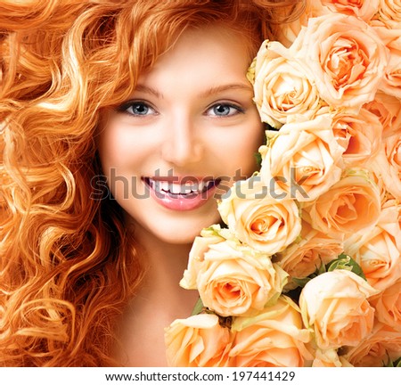 Beauty model girl with long curly red hair and beautiful red roses hairstyle. Fashion woman with Wavy healthy hair. Cute smiling teenage girl. Permed hair