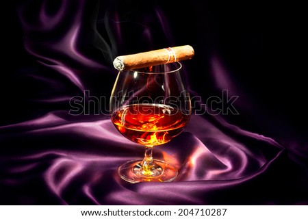 Cognac and Cigar. Glass of Brandy over dark background