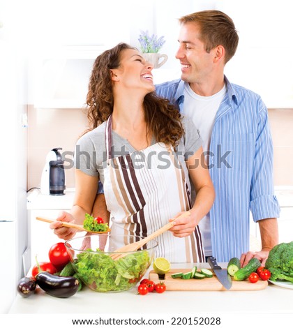 Happy Couple Cooking Together - Man and Woman in their Kitchen at home Preparing Vegetable Salad.Diet.Dieting. Healthy Food. Vegan food concept