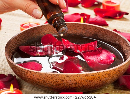 Aromatherapy. Essence oil. Spa treatment Beauty Spa treatment. Bowl of water with red rose petals