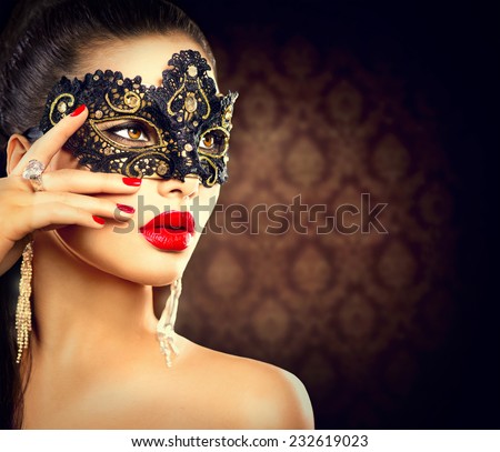 Beauty model woman wearing venetian masquerade carnival mask at party, over holiday dark background. Christmas and New Year celebration. Sexy girl with holiday makeup and manicure. Red lips and nails