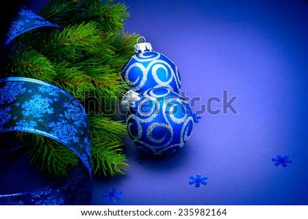 Christmas blue baubles with ribbon and snowflakes over Blue background. Xmas tree New Year decoration art design