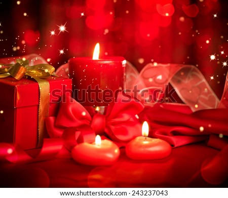 Valentine\'s Day. Valentine Red Heart shaped candles and Gift on Red Silk Background. Beautiful Valentine card art design