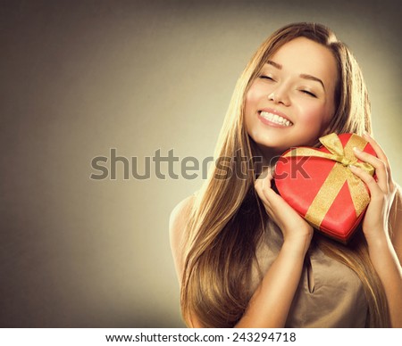 Beauty happy girl with Valentine Gift box. Smiling surprised model girl takes heart shaped red present.