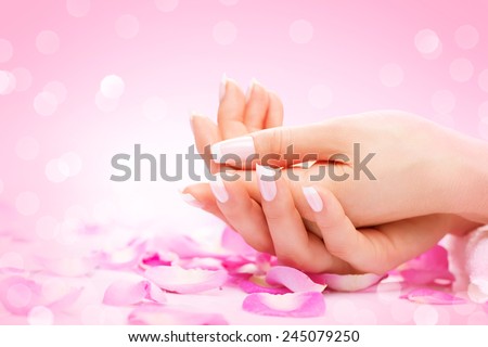 Manicure, Hands spa Beautiful woman hands, soft skin, beautiful nails with pink rose flowers petals. Healthy Woman hands. Beauty salon. Beauty treatment.  Female nails with beautiful french manicure