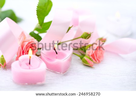 Valentine\'s Day. Valentine Gift. Pink Heart shaped candles and rose flowers on white wooden background. Beautiful Valentine card art design