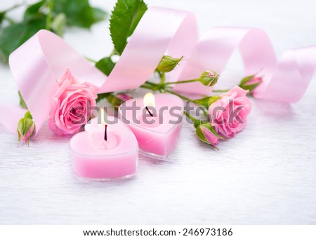 Valentine\'s Day. Valentine Gift. Pink Heart shaped candles and rose flowers on white wooden background. Beautiful Valentine card art design