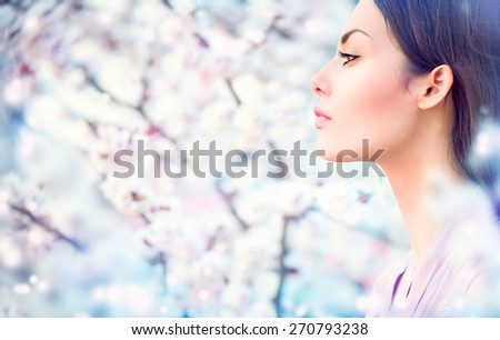 Spring fashion girl outdoor portrait in blooming trees. Beauty Romantic woman in flowers. Sensual Lady. Beautiful Woman Enjoying Nature. Romantic beauty in fantasy orchard