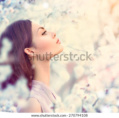 Spring fashion girl outdoor portrait in blooming trees. Beauty Romantic woman in flowers. Sensual Lady. Beautiful Woman Enjoying Nature. Romantic beauty in fantasy orchard