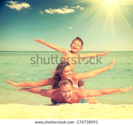 Happy Family Having Fun at the Beach. Joyful Family. Vacation and Travel concept. Summer Holidays. Parents with Son enjoying a holiday at the sea. Toned photo