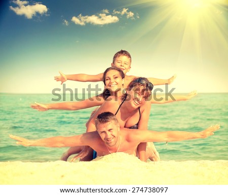 Happy Family Having Fun at the Beach. Joyful Family. Vacation and Travel concept. Summer Holidays. Parents with Children enjoying a holiday at the sea