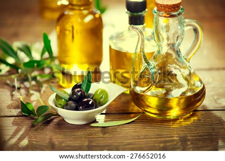Olives. Green and black olive closeup. Olives and Olive Oil on the wooden table. Healthy food, Mediterranean cuisine