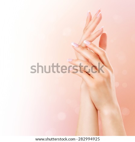 Beautiful Female Hands. Spa and Manicure concept. Woman hands with french manicure. Soft skin, skincare concept. Beauty nails. over beige background