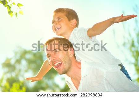Happy Father and Son having fun outdoors. Laughing Dad with Little Boy enjoying nature together. Joyful Family. Free,freedom concept. Summer Holidays, vacation