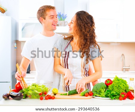Happy Couple Cooking Together - Man and Woman in their Kitchen at home Preparing Dinner - Vegetable Salad. Diet. Dieting. Healthy vegetarian food, vegan. Family cooking together at home