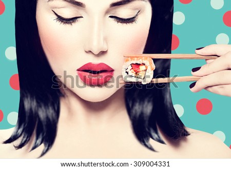 Fashion art portrait of beauty model girl eating Sushi roll, healthy japanese food. Beautiful woman holding chopsticks with sushi. Sexy lady