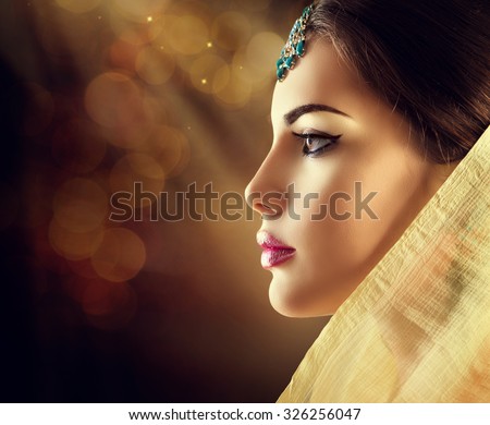 Beautiful fashion Indian woman profile portrait with oriental accessories. Indian girl with beauty jewels. Hindu model with perfect make-up. India