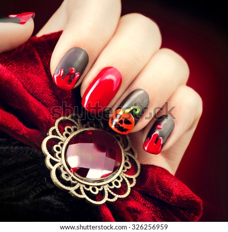 Halloween Nail art design. Nail Polish. Beauty hands. Trendy Stylish Colorful Nails and Nailpolish. Black matte nailpolish with blood drips and pumpkin
