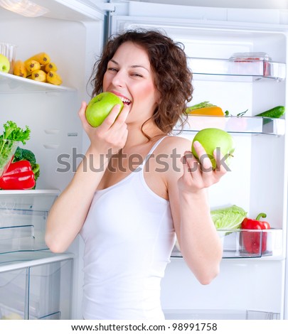 Healthy Eating Concept .Diet. Beautiful Young Woman near the Refrigerator with healthy food. Fruits and Vegetables