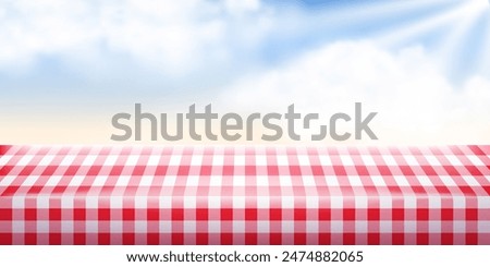 Summer or spring picnic background. Red checkered tablecloth and blue sunshine sky with clouds. Empty space food table. Tabletop advertisement backdrop