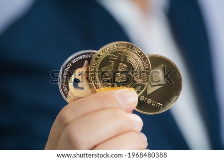 Golden bitcoin coin Dogecoin DOGE, Ethereum ETH group included with Cryptocurrency on hand business man wearing a blue suit. Filed and put and give to me. Close up and Macro photography concept.