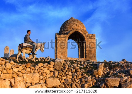 Mardin ,Turkey - 06/02/2014 : Ancient city of Dara in Mardin.Young boy riding donkey.