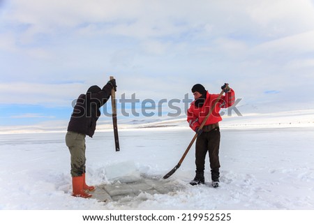 KARS,TURKEY - 30/01/2013 : Fishermen catches fishes on Lake Cildir (Cildir Golu) which is frozen every winter.The Lake is located on Eastern Anatolia,Kars which is one of the coldest city in Turkey.
