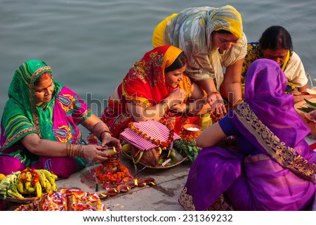 VARANASI,INDIA - October 29,2014 : Unidentified Indian women pray and devote for Chhath Puja festival on Ganges river side in Varanasi,India