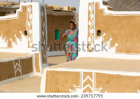 JAISALMER,INDIA - November 9,2014 : Unidentified indian woman stands in front of her traditionally painted house
