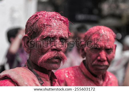 MATHURA,INDIA - March 28,2013 :Unidentified men painted  with  powder paints and water thrown by the others during the Holi celebration in Mathura.Holi festival  is one of the most colorful event