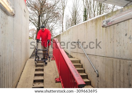 Worms, Germany - December 1, 2010: Old man having difficulties to move barrier-free though his city