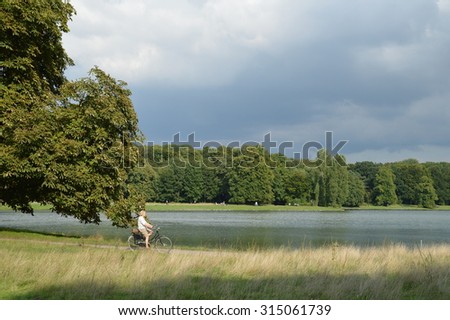 Cologne, Germany - August 31, 2015 - Joggers, walkers and cyclists in urban park and local recreation area in Cologne use free time for recreation in green lung of modern cities