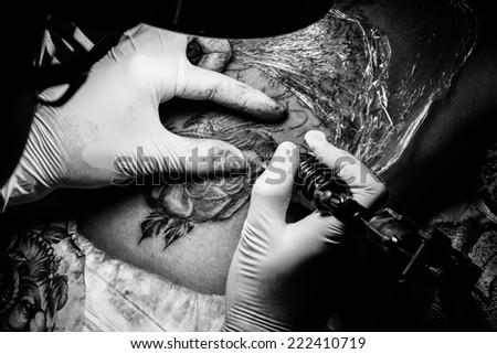 tattooer showing process of making a tattoo. Tattoo design in pattern