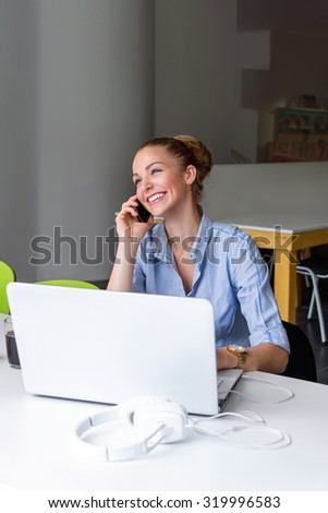 Business, technology and green office concept - young successful businesswoman with laptop computer talking on the phone at office. Beautiful woman using tablet computer