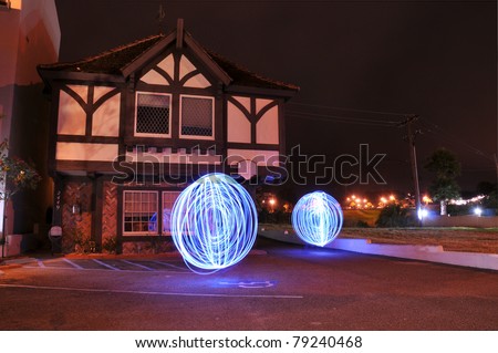 Abstract long exposure photograph of two mysterious paranormal orbs in front of an old building