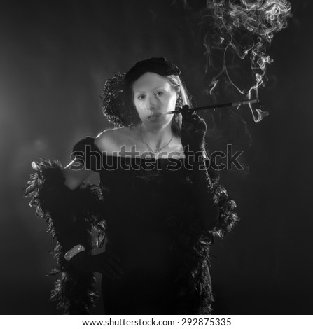 Black and White Portrait of Glamorous Woman Smoking Cigarette and Dressed in Vintage Clothing, Standing with Hand on Hip, Waist Up Portrait in 1940s Film Noir Style