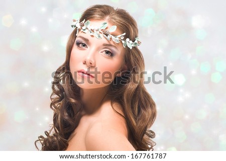 Portrait of a young girl with turquoise eyes on the silver shining background / Winter holiday makeup