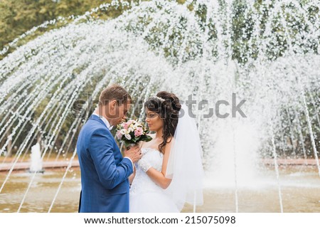 Bride and groom. Wedding walk. City fountain.