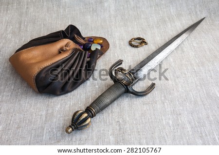 daga and leather purse with semi-precious stones on linen cloth