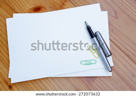 blank white notebook  and  pen  on the desk
