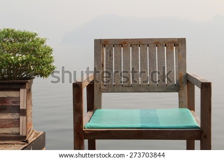 Wooden chair on wooden floor near the lake.