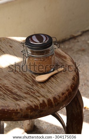 Closeup of brown sugar in sugar bowl on wooden table.
